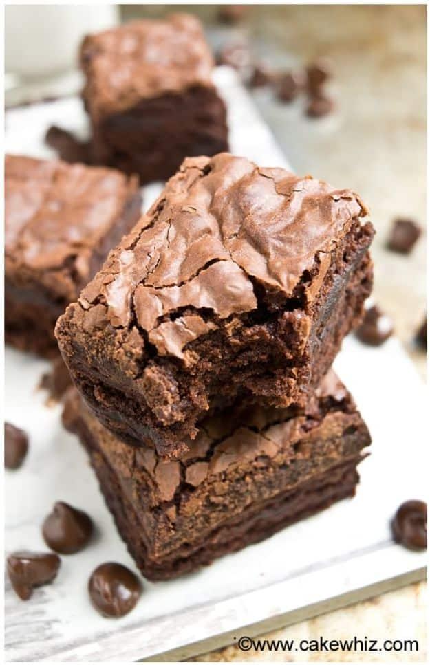 Fudgy brownies with crackly shiny tops, cut into squares and photographed close up to show the crumb