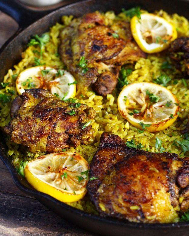 One pot Middle Eastern chicken and rice in a cast iron pan, yellow turmeric rice with browned thighs and lemon