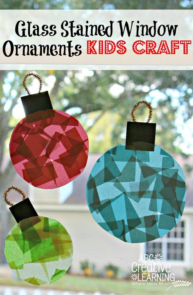 Three tissue paper stained glass ornaments in red, blue and green with black paper frames, stuck to a bright window
