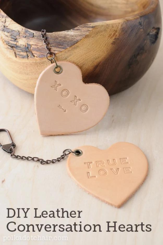 Leather conversation hearts stamped with short messages laid out on a table as handmade Valentine gifts