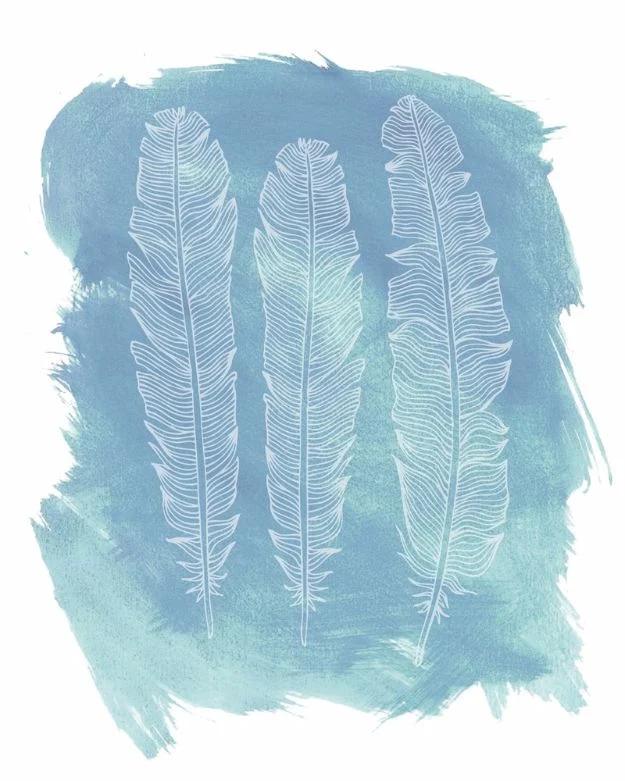 Free feather printables, three pale feathers reversed out of a loose teal and slate watercolor wash on white paper