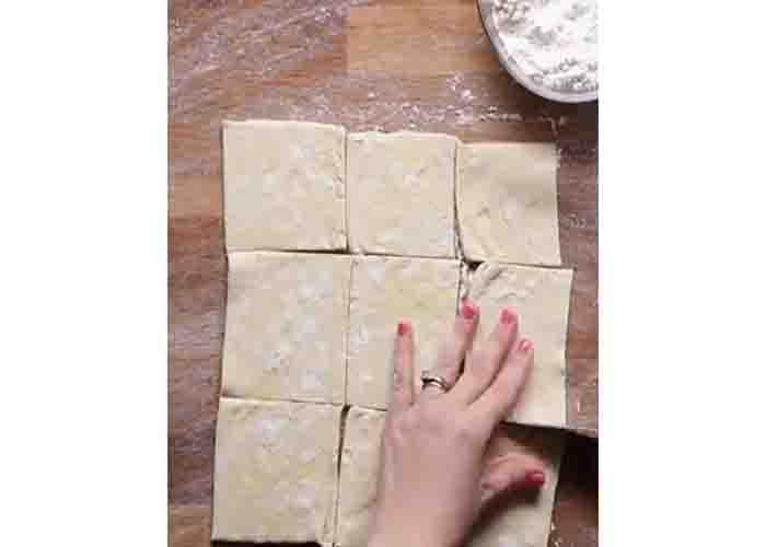 Cutting the puff pastry to nine pieces to make the breakfast cups