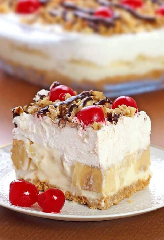 No bake banana split dessert in a pan with bananas, pineapple, whipped topping, nuts and cherries, an easy no bake dessert