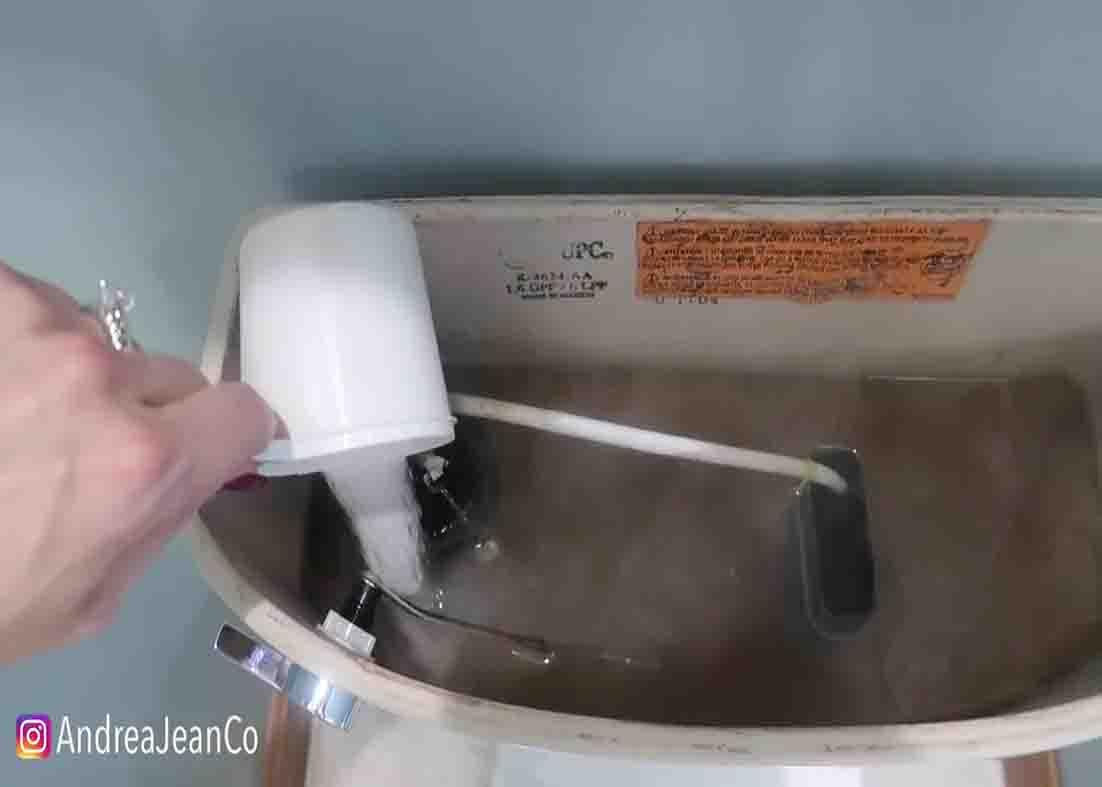 Pouring 1 cup of citric acid to the toilet tank