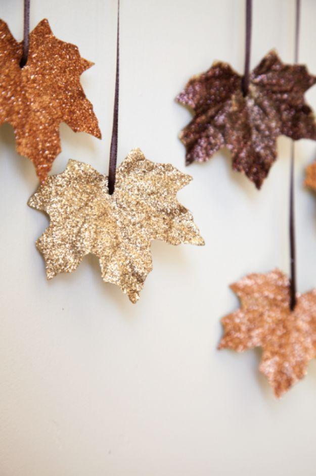 Falling leaves garland of glittered gold, copper and brown artificial maple leaves hanging on brown ribbons