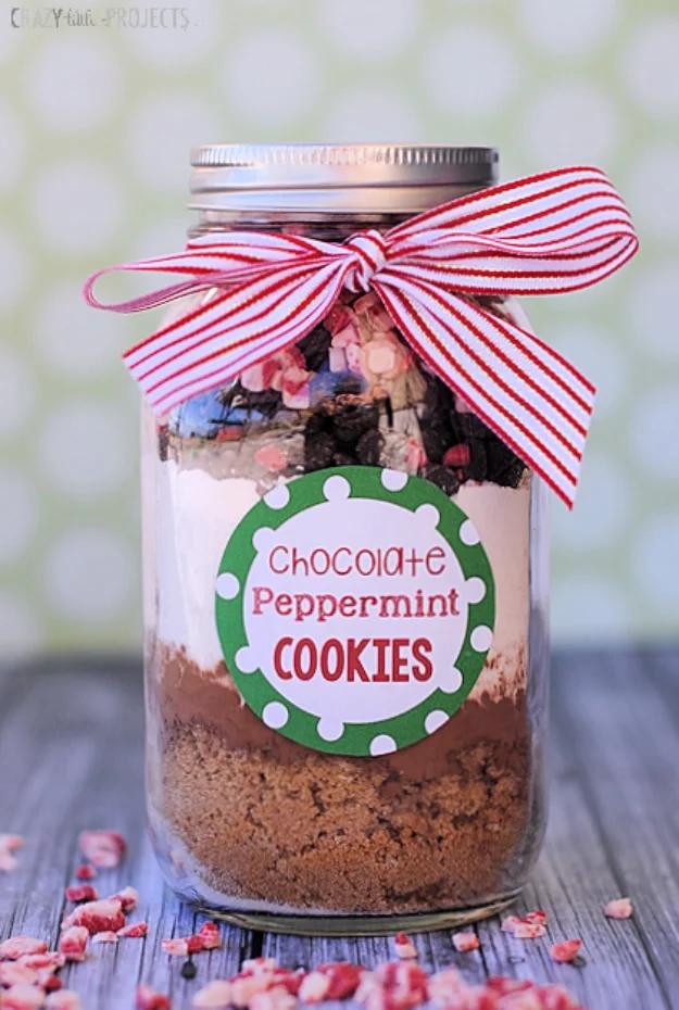 Mason jar of layered double chocolate peppermint cookie mix with a red striped ribbon and a round gift tag