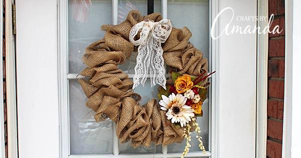 Classic burlap wreath made from a coat hanger with a lace bow and silk flowers hanging on a door