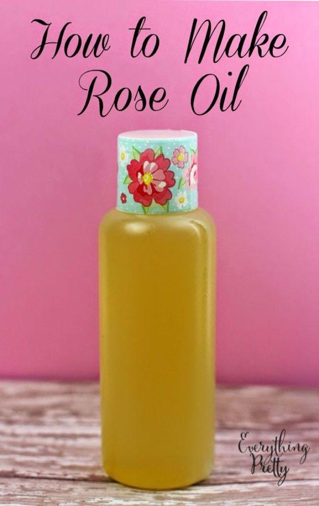 Homemade rose oil, a bottle of golden infused oil with a floral label standing on white wood against a bright pink background