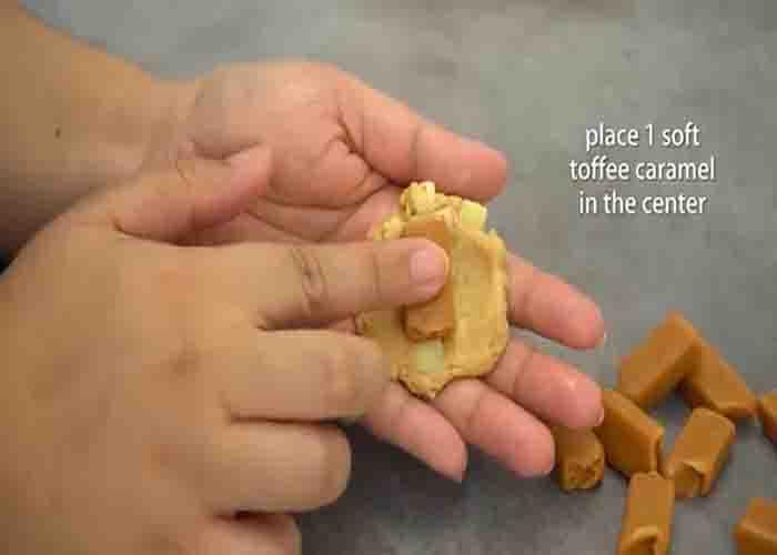 Adding a caramel on the center of the apple cookies