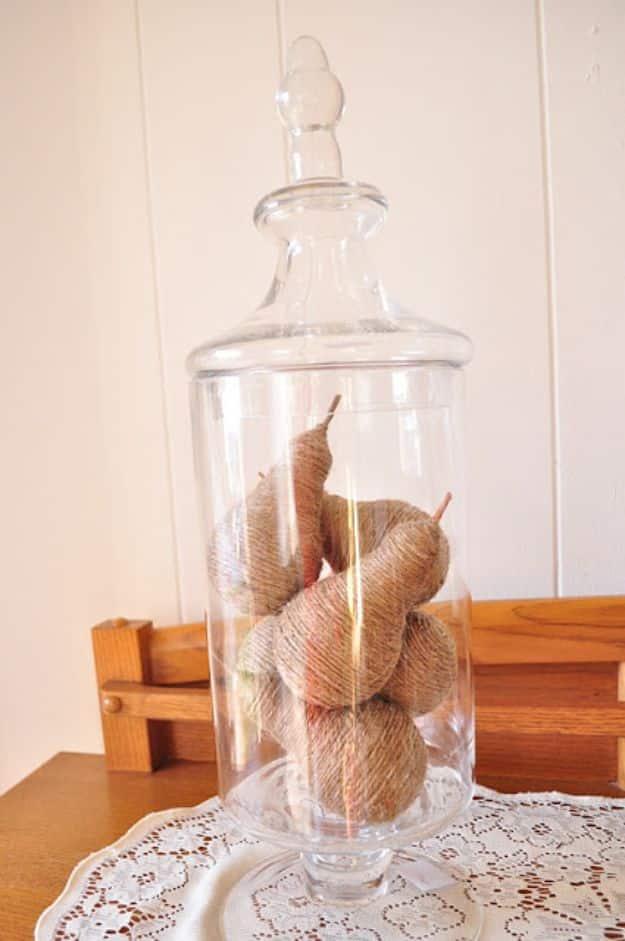 Twine wrapped light bulb pears displayed in a glass apothecary jar, an easy beginner DIY home decor idea