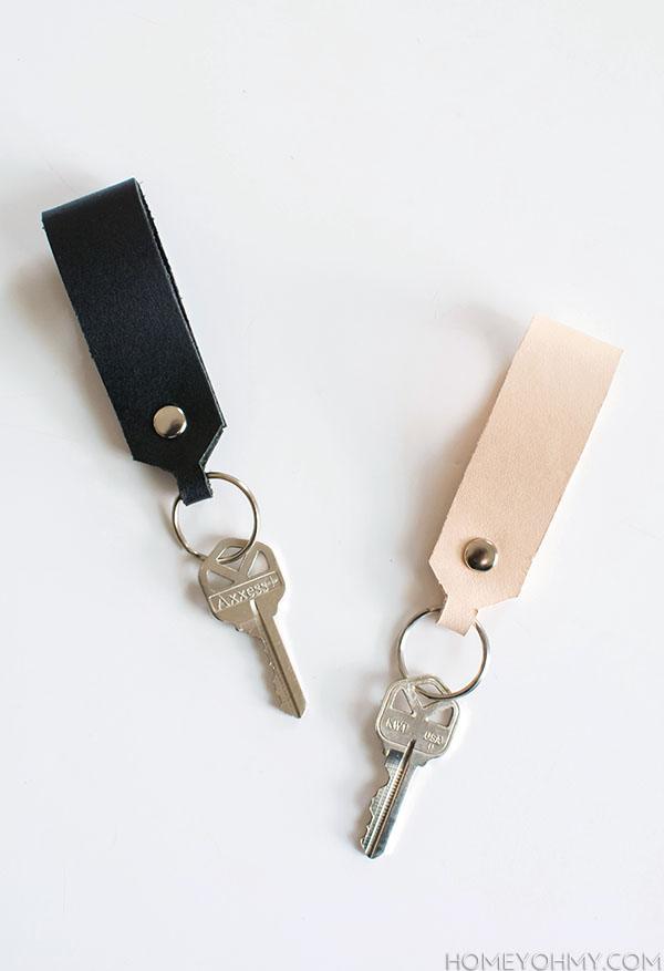 Black and natural leather loop keychains fastened with silver rivets, one on a key ring holding two keys