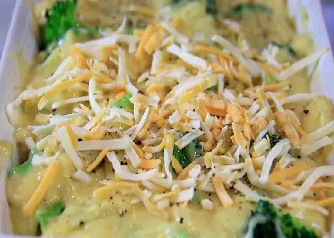 Adding cheese over the top of the chicken and broccoli
