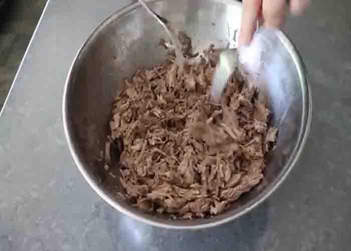 Shredding the kalua pork into small pieces