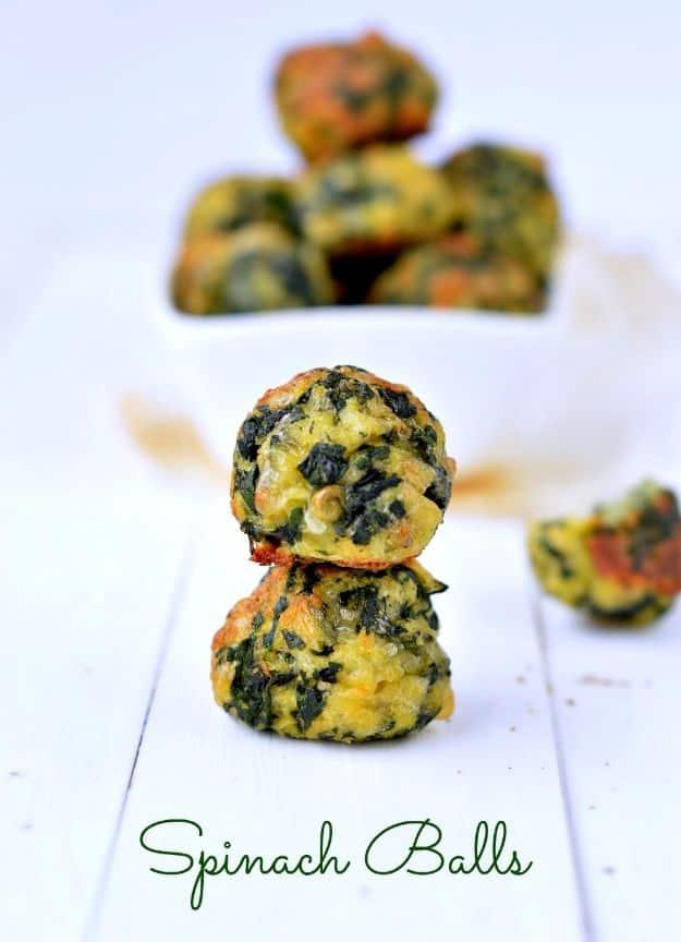 Typeset pin graphic reading Spinach Balls below a photo of green baked spinach balls on a white board