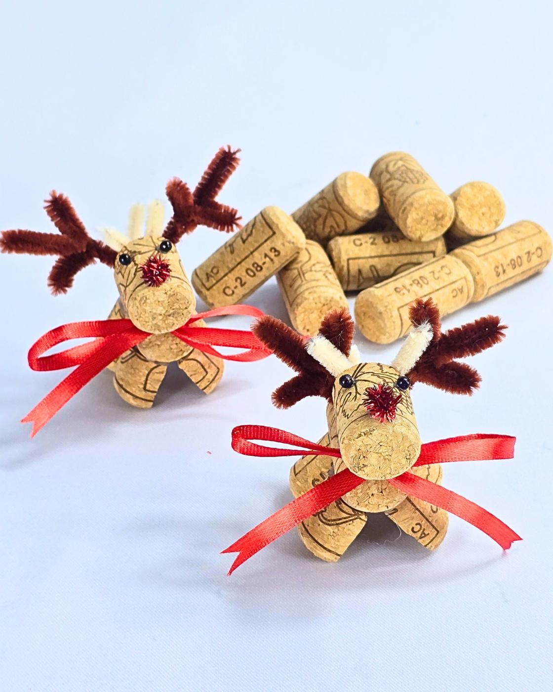 Wine Cork Crafts - two handmade cork reindeer standing beside a small pile of loose corks