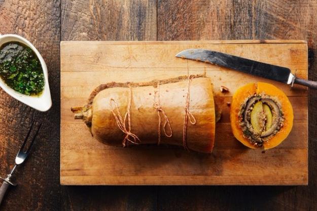 Butternut squash vegducken sliced open to show layers of eggplant, zucchini and mushroom pecan stuffing