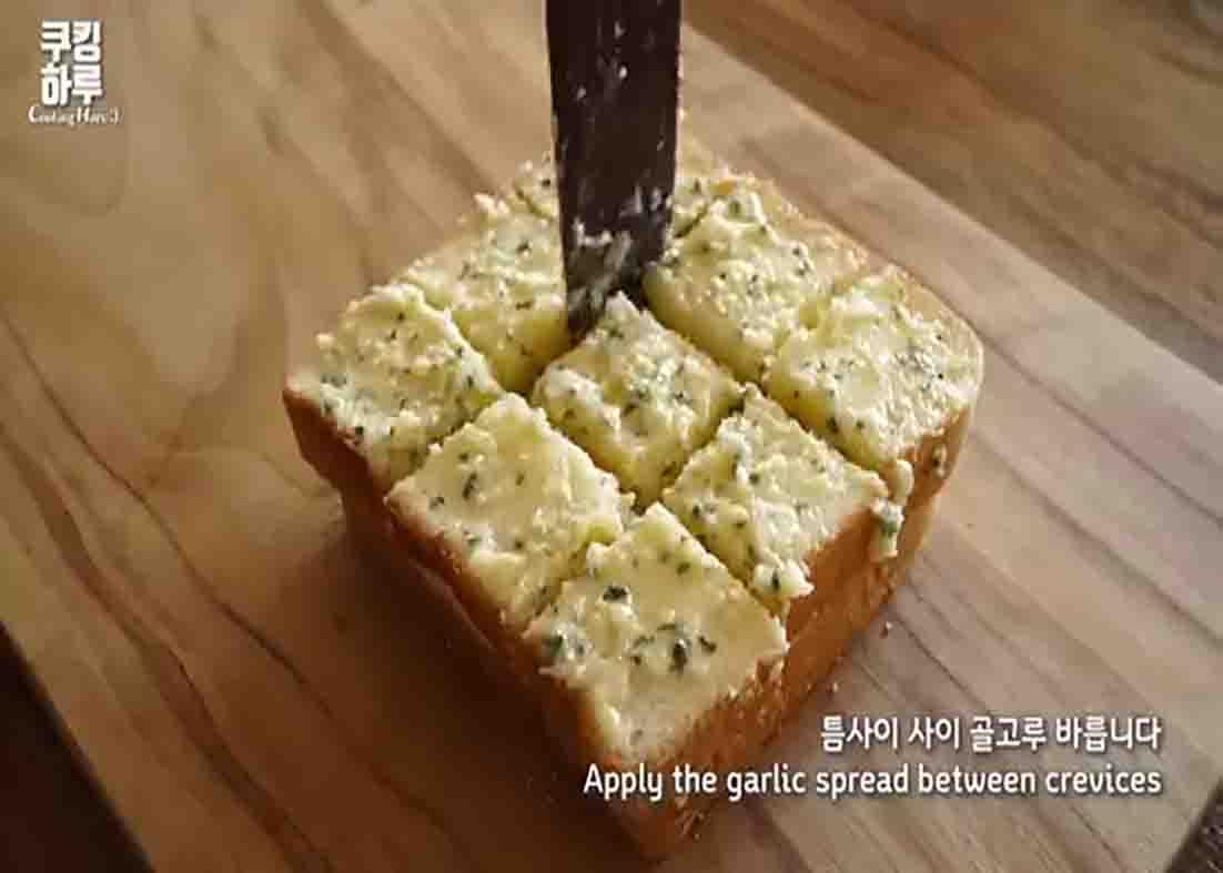 Spreading the garlic spread over the bread