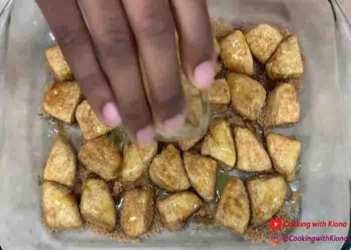 Coating the Pillsbury biscuit bites with sugar and cinnamon
