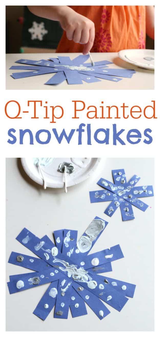 Blue paper strip snowflakes dotted with white and silver paint, with an inset of a child painting one with a q-tip