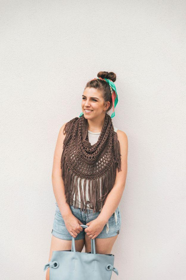 Woman in a brown open crochet fringed cowl over a sleeveless denim top, with a teal scarf tied in her topknot