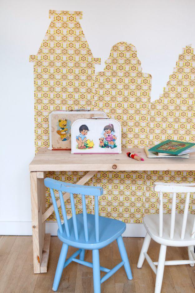 Wallpaper cityscapes, a yellow retro patterned skyline of cut paper houses and towers behind a plywood desk