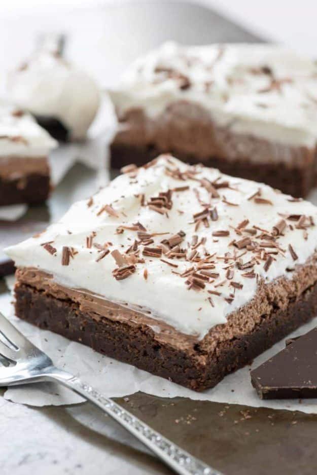 French silk brownies with a thick chocolate mousse layer and whipped topping finished with chocolate shavings