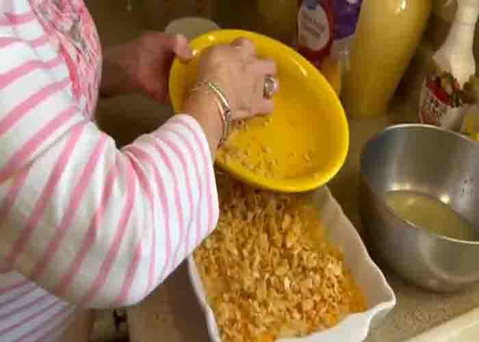 Topping the pineapple casserole with Ritz crumble