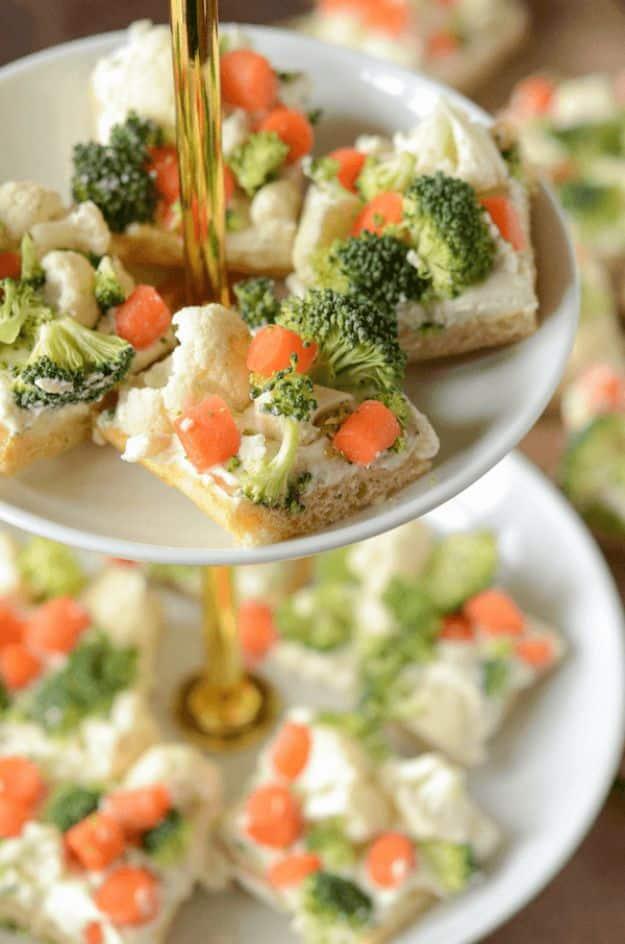 Ranch veggie bars topped with finely chopped broccoli, cauliflower and carrot on a crescent roll crust