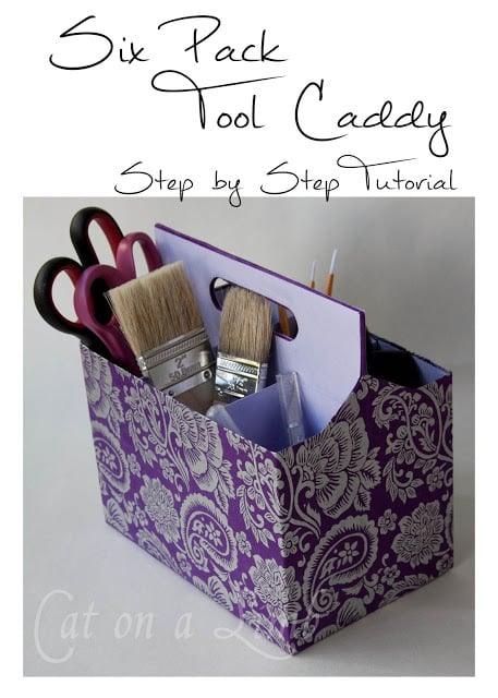Cardboard six pack carrier wrapped in purple damask paper holding brushes and scissors, under a typeset tutorial title