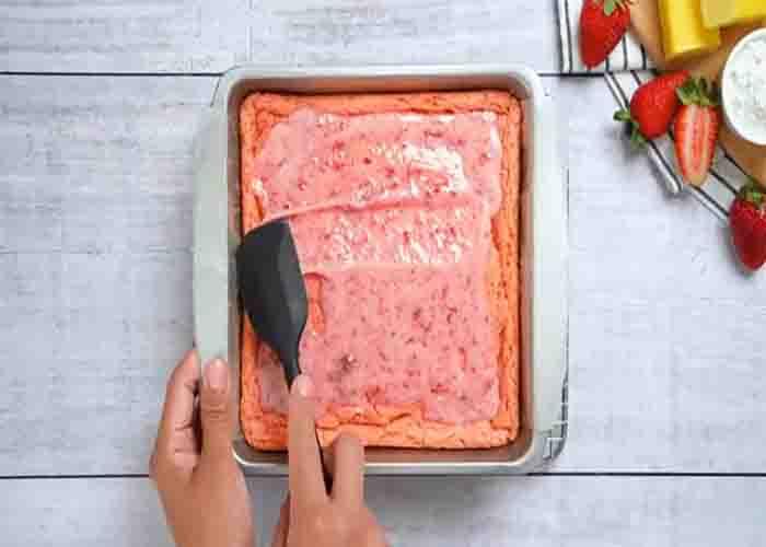 Spreading the glaze over the strawberry brownies