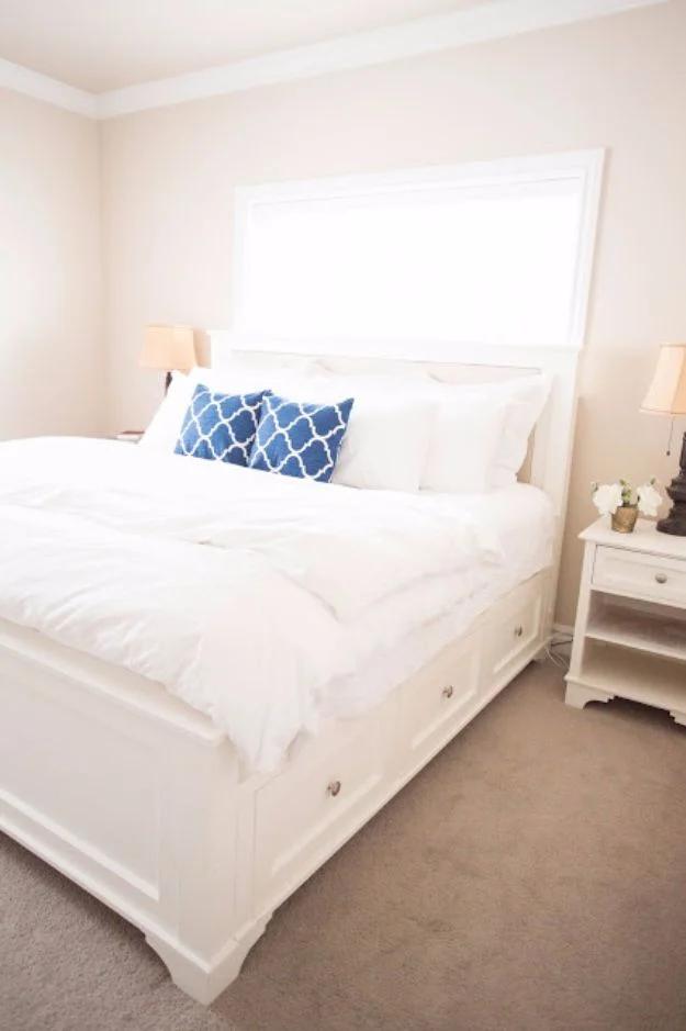 Photograph of a white king bed with a framed panel headboard and two storage drawers built into the base