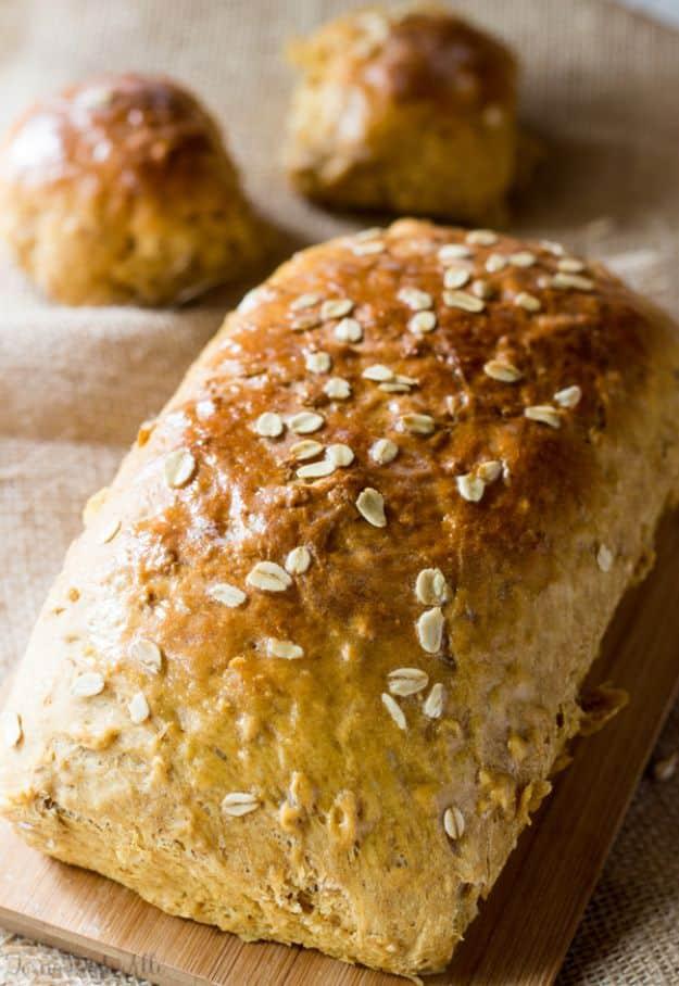 Oatmeal molasses bread baked dark brown with a crisp crust, sliced to show a soft moist oat flecked crumb