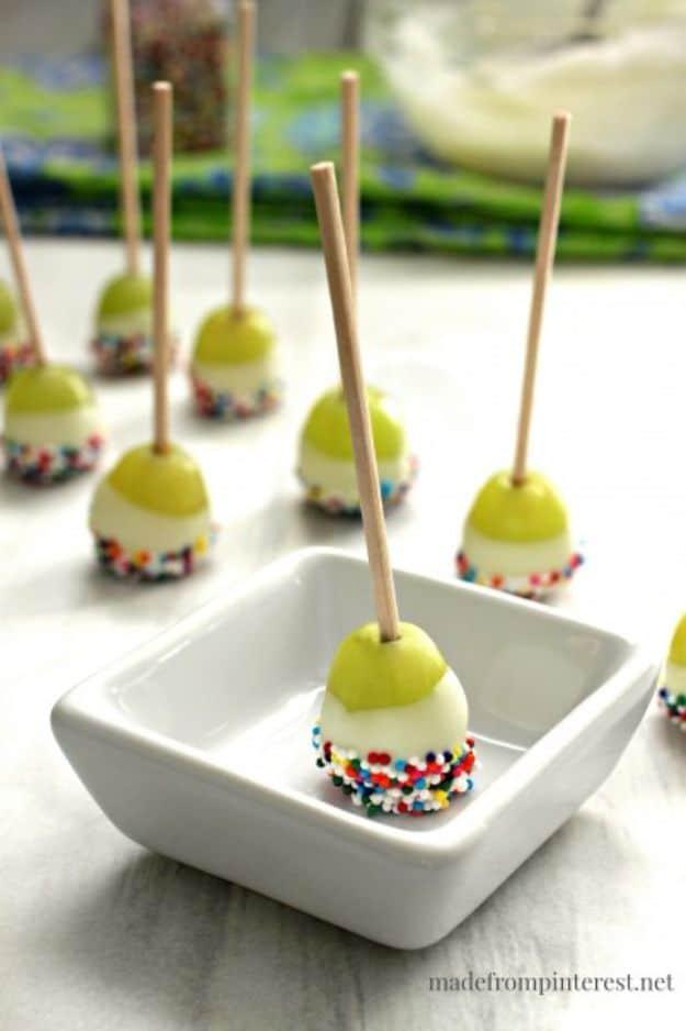 Grape poppers coated in vanilla candy coating and rolled in nonpareils and chopped pecans, a frozen candy coated fruit snack