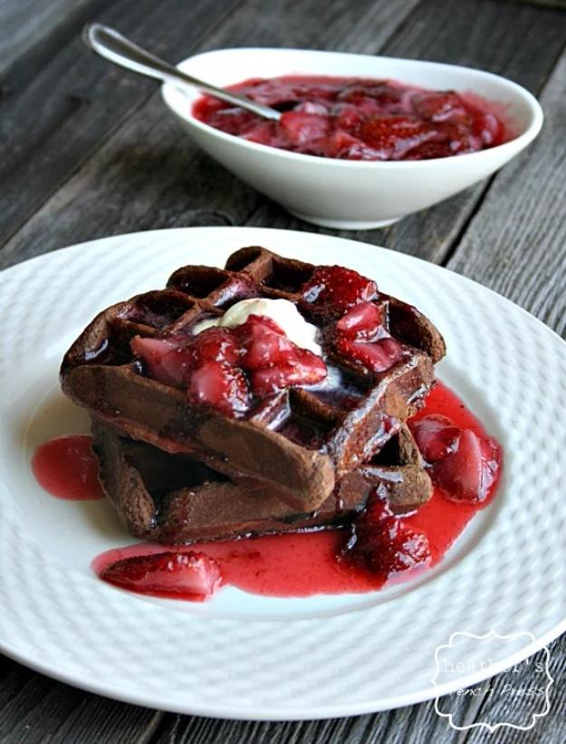 Brownie batter cooked in a waffle iron into ridged brownie waffles, drizzled with red strawberry syrup