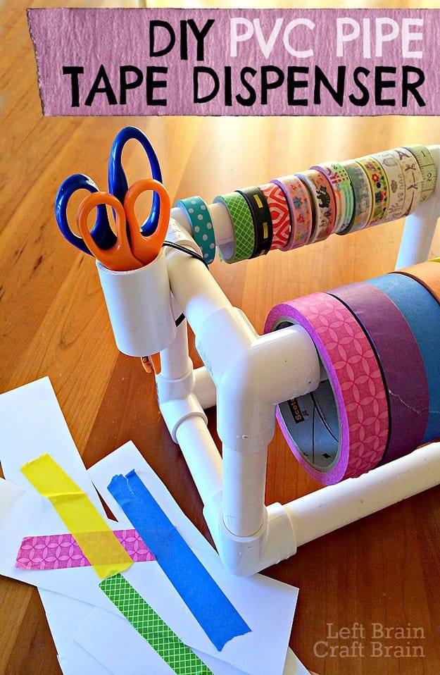 Rectangular white PVC pipe frame holding rolls of washi and masking tape on a bar, with scissors hanging at a corner
