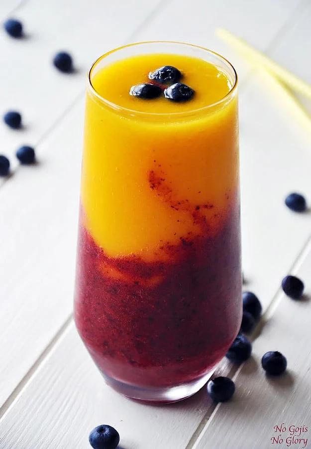 Mango berry smoothie blended cool and refreshing with frozen fruit for a bright hot summer morning drink
