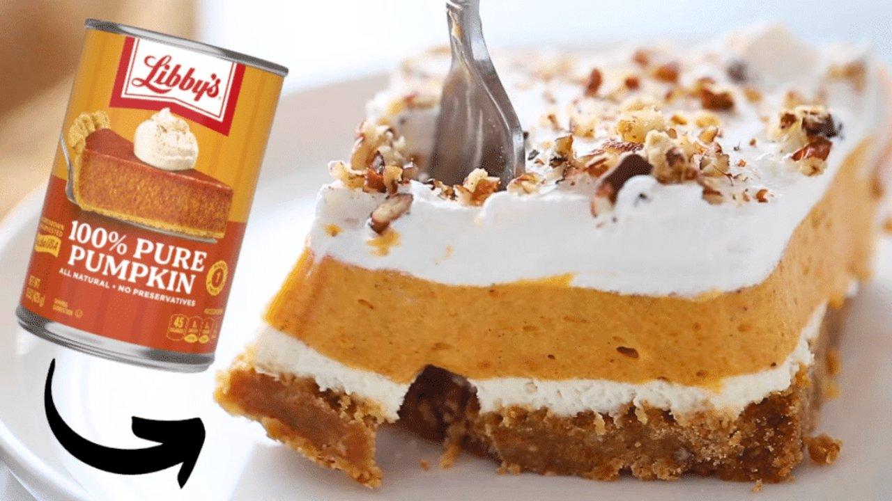 Slice of layered pumpkin delight with graham crust, cream cheese, pumpkin pudding and whipped topping