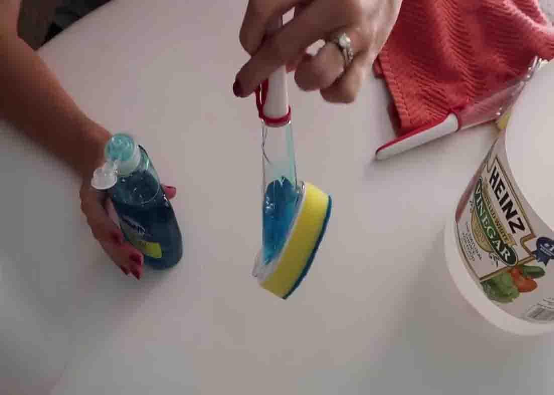 Mixing the liquid soap and the vinegar to form the solution