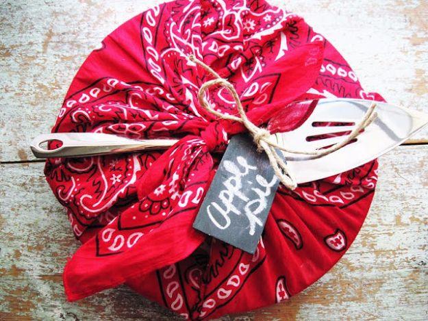 Bandana apple pie wrap, a pie knotted into a red bandana with a chalkboard tag and two metal servers