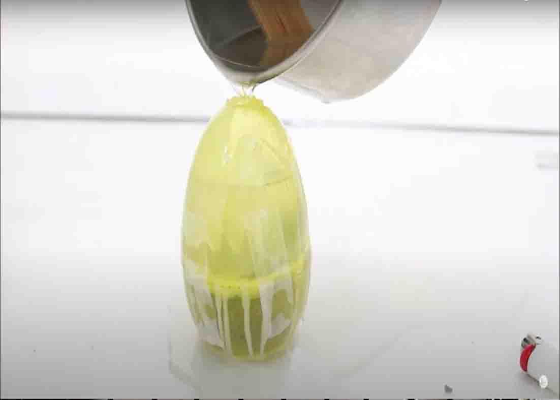 Filling the egg mold with candle wax