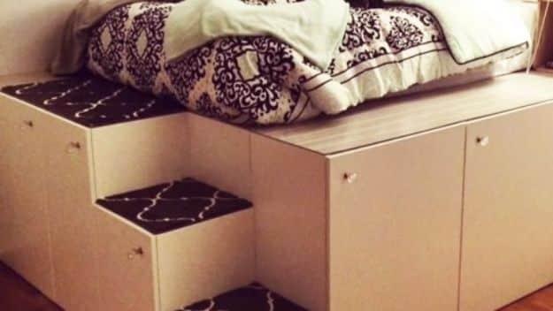 Photograph of a platform bed base built from pale flat pack cabinet units with a built in step, topped with patterned bedding