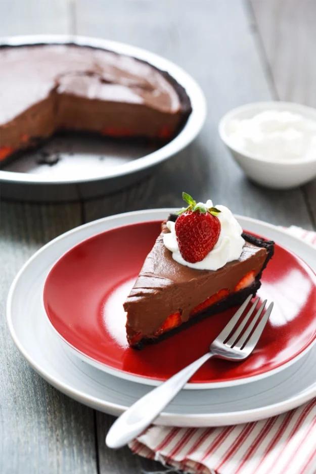 Chocolate strawberry oasis pie with halved strawberries lining a dark cookie crust under chocolate custard