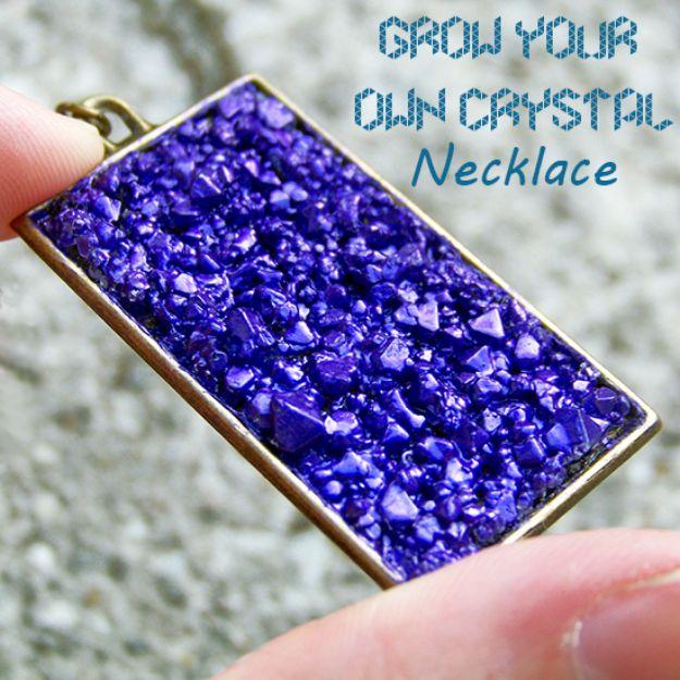 Fingers holding a rectangular metal pendant filled with deep violet grown crystals, under a typeset title