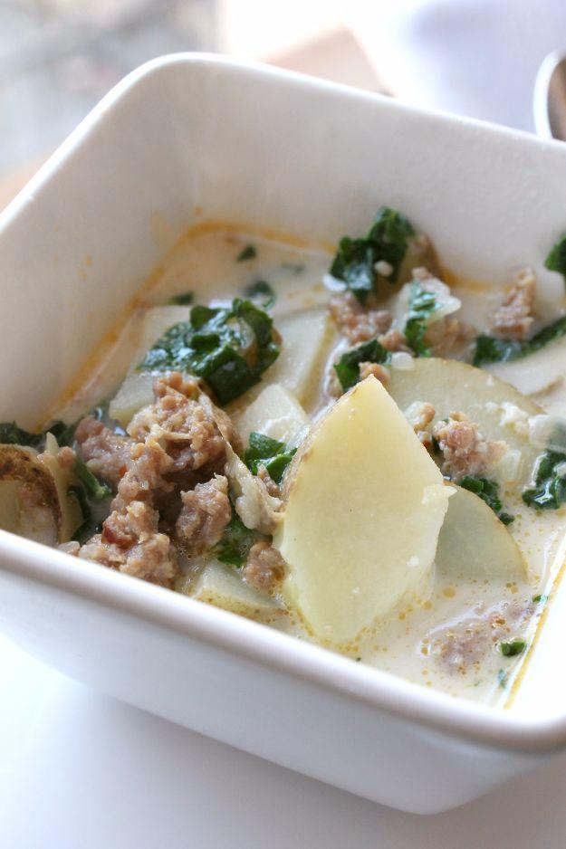 White square bowl of zuppa toscana with crumbled sausage, torn kale and sliced potatoes in a creamy broth