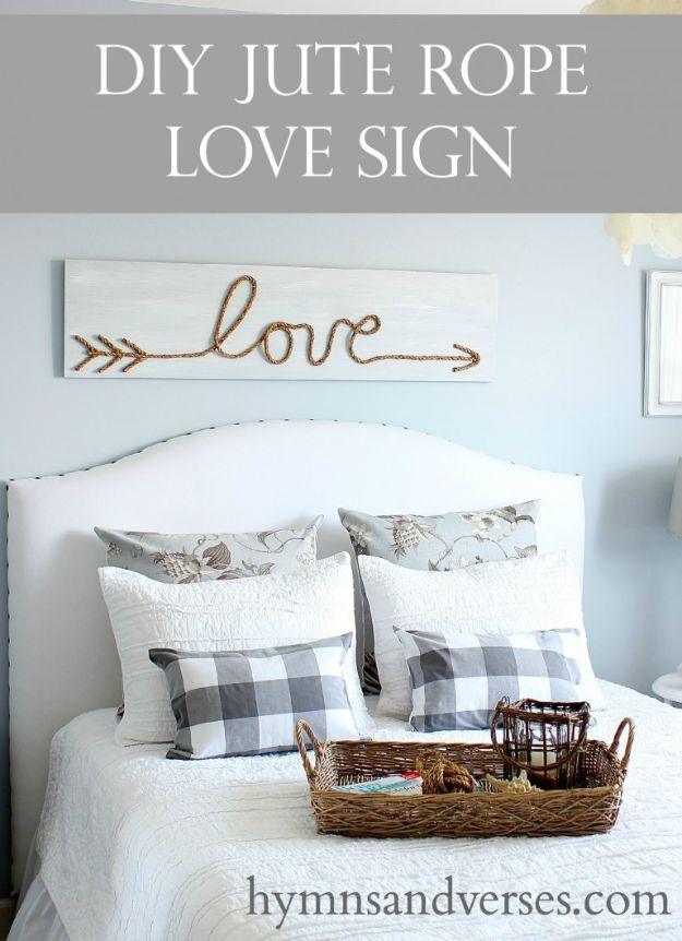 DIY jute rope love sign, a long whitewashed board with a word formed in jute rope, hung above an upholstered bed