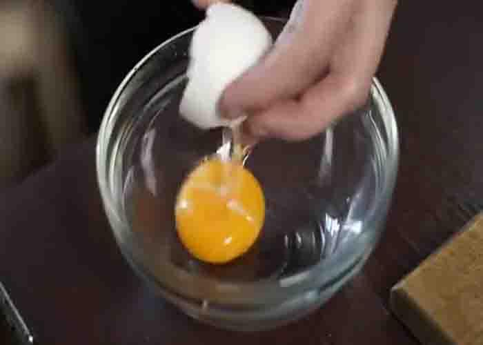 Cracking an egg for the homemade remedy for wrinkled hands