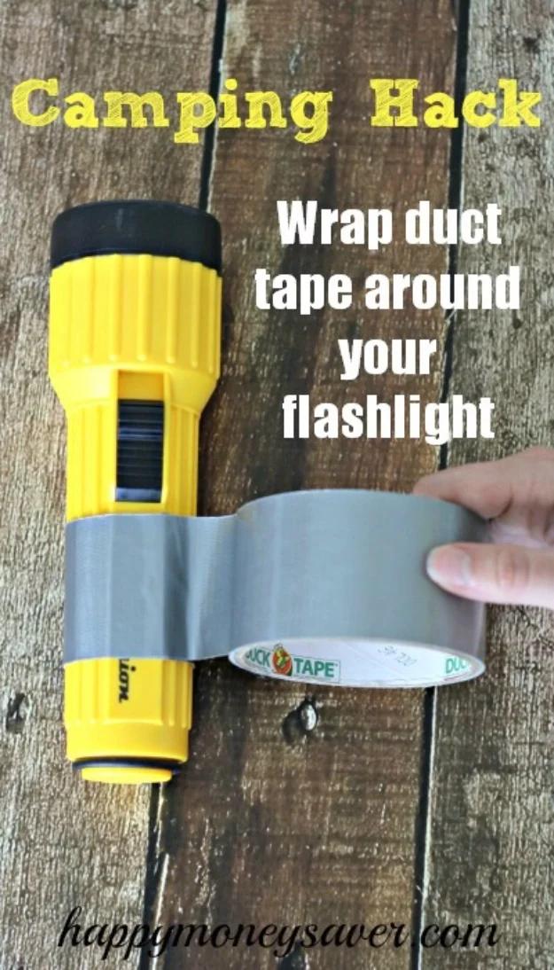 Camping hack graphic, a hand winding a roll of silver duct tape around a yellow flashlight on grey boards