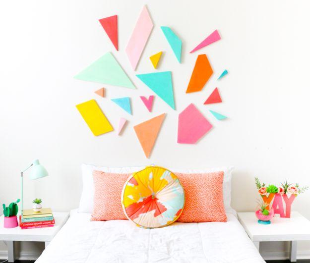 Colorful painted geometric shapes arranged as a headboard above a white bed, an easy beginner decor idea