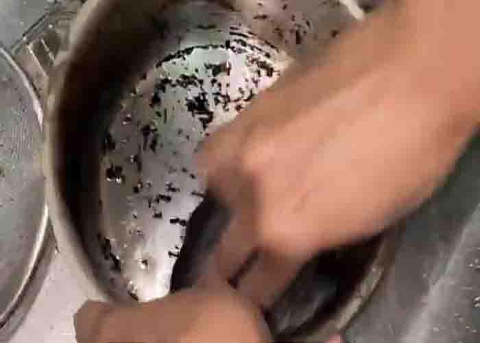 Scrubbing the burnt pot with a scrubber