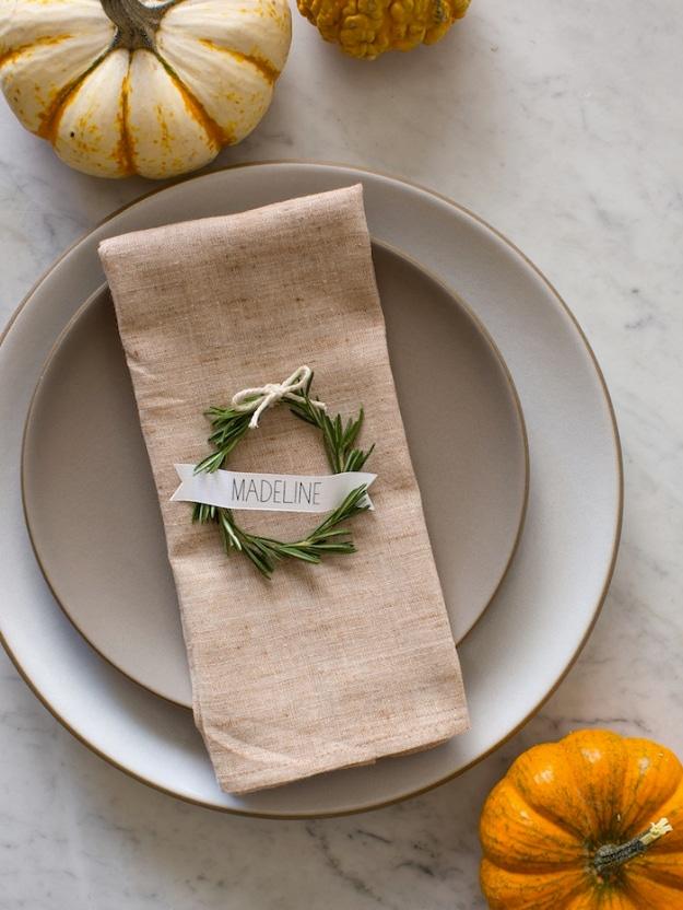 Rosemary wreath place cards made from bent rosemary sprigs tied with ribbon and a curled paper name tag